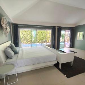 a bedroom with a white bed and a large window at Purin Resort & Restaurant- SHA Plus in Had Yao Beach