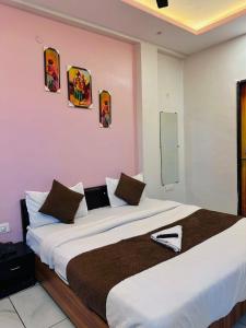 a bedroom with a large bed in a pink wall at Hotel Castle in Indore