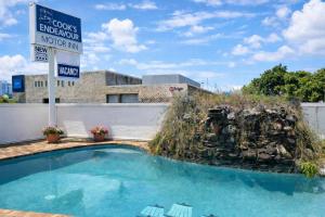 a sign next to a small swimming pool at Cooks Endeavour Motor Inn - Near beach & Gold Coast Airport in Tweed Heads