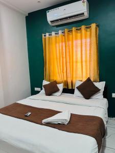 a bedroom with two beds with an orange curtain at Hotel Castle in Indore