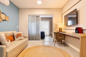 ein Wohnzimmer mit Couch und Schreibtisch in der Unterkunft Wyndham Natal Pitangui Praia in Extremóz
