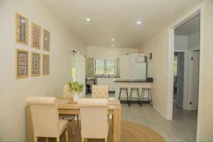 a kitchen and dining room with a table and chairs at 2 Bedroom House - Villa Teremoana in Ngatangiia