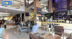 a restaurant with tables and chairs in a store at Horison Ultima Makassar in Makassar