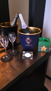 zwei Flaschen Wein in einem Eimer auf einem Tisch mit Gläsern in der Unterkunft Sparano Palace - Luxury Maison in Bari