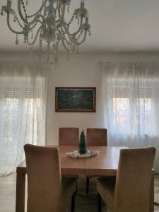 uma sala de jantar com mesa, cadeiras e um lustre em Rosdani Apartment em Palermo