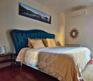 a bed with a blue headboard in a bedroom at Chambre Chez l'habitant "Maïssi" in Sablons