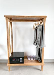 een houten tafel met een magnetron en een plank met kleding bij PIDA COFFEE FARM LODGE in Phumĭ Pu Pal