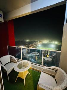 a balcony with chairs and tables and a view of the ocean at Hulk apartment in Ghaziabad