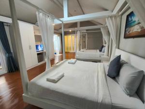 a bedroom with a large white bed and a tv at Purin Resort & Restaurant- SHA Plus in Had Yao Beach