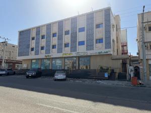 een gebouw met een auto ervoor geparkeerd bij ركن صحاري للشقق المخدومة ضبا Rukn Sahari for Served Apartments in Ḑubā