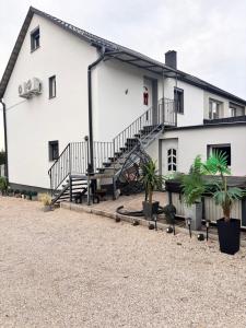 ein weißes Gebäude mit Treppen und Topfpflanzen in der Unterkunft Csobogó Suites Apartman in Keszthely