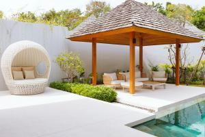 eine Terrasse mit einem Pavillon neben einem Pool in der Unterkunft Anchan Flora Luxury 2BR Pool Villa in Thalang