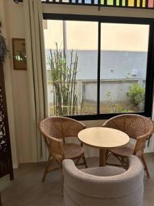 a table and chairs in a room with a window at Fluffy Cat Paradise in Ko Bu Bu