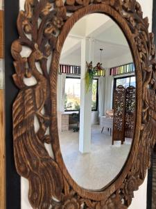 a mirror with a wooden frame in a living room at Fluffy Cat Paradise in Ko Bu Bu