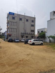 een groep auto's geparkeerd voor een gebouw bij Rajeshwari Tower & Residency in Tiruvannamalai +4 foto's