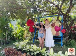 two women posing for a picture in front of a garden at Casa de Capybara in Siem Reap