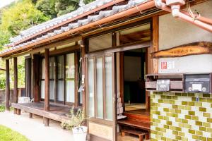 a porch of a house with a bench on it at 一軒宿さめうら 最大8名宿泊 ペット可 一棟貸切 in Nakajima