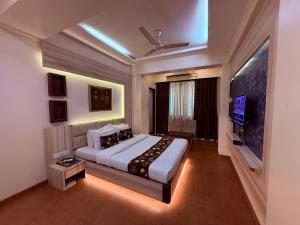 een slaapkamer met een groot bed en een tv bij Hotel Alka Residency in Thane