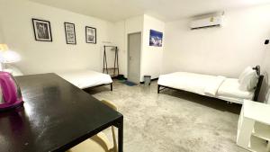 een kamer met twee bedden en een tafel erin bij WAKE UP @Lanta Hotel : Cafe in Koh Lanta