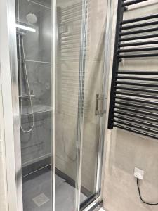 een douche met een glazen deur in een badkamer bij Appartement 5 Climatisé confort moderne dans un t2 chaleureux in Limoges