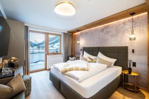 a bedroom with a large white bed and a window at Boutique Hotel Montanara in Ischgl
