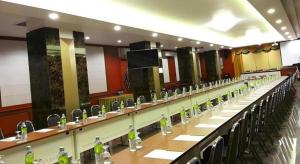 een kamer met rijen tafels waarop flessen staan bij Nartsiri Hotel in Ubon Ratchathani