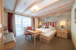 a bedroom with a large bed and a table at Boutique Hotel Montanara in Ischgl