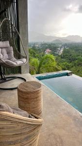 a swimming pool sitting next to a wicker chair next to at VISTA Cadlao in El Nido Airport