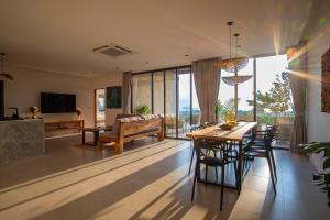 een eetkamer en woonkamer met een tafel en stoelen bij Inn Harmony Villa Seaview in Ko Pha Ngan