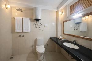 ein Badezimmer mit Toilette, Waschbecken und Spiegel in der Unterkunft Hotel Hollywood Vibes #riverview #premium rooms #prime location #most awarded #parking #top rated #open terrace #lawn #best selling hotel in manali in Manali + 54 Fotos