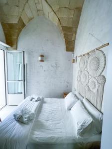 a white bed in a room with a large window at Palma Residence Salento in San Foca