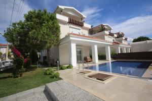 a villa with a swimming pool in front of a house at Lighthouse Lydia Villas in Fethiye