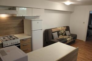 a kitchen with a couch and a chair in a room at Apartmány pri Auparku in Piešťany