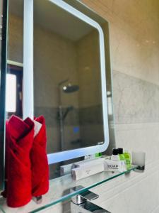 a bathroom with a mirror and red towels on a sink at New Aqua Glory in Negombo +34 photos