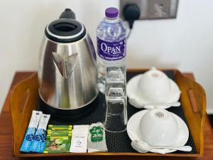 a tray with a tea kettle and a bottle of water at New Aqua Glory in Negombo