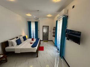 a living room with a couch and a tv at New Aqua Glory in Negombo