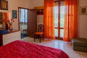 a bedroom with a red bed and a window at Agriturismo Artisti Del Cavallo in Foiano della Chiana