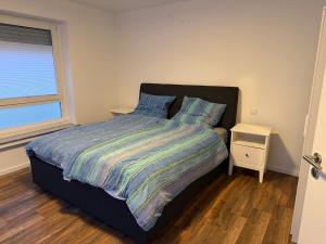 een slaapkamer met een bed met een gestreept dekbed en een raam bij Centrally located in Coesfeld in Coesfeld