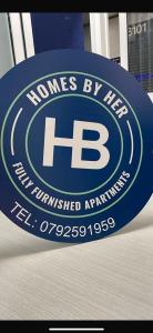 ein blaues Schild mit dem Hones Bymet-Logo darauf in der Unterkunft Homes by her in Entebbe