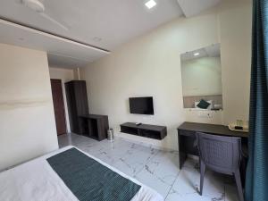 a hotel room with a bed and a television at Hotel Space Comfort Inn in Karmād
