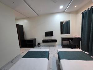 a hotel room with two beds and a desk at Hotel Space Comfort Inn in Karmād