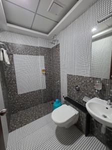 a bathroom with a toilet and a sink at Hotel Space Comfort Inn in Karmād