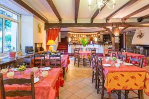 a restaurant with tables and chairs in a room at Hôtel du Val d'Aure in Cadéac