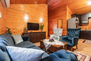 un soggiorno con divano, sedie e TV di House Holiday Dilek a Kemer