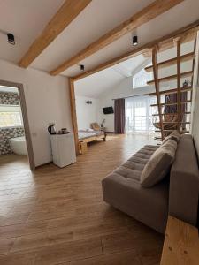 a living room with a couch and a wooden floor at Гостинний двір in Yaremche