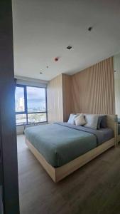 a bedroom with a large bed with a large window at Kuno - 2Br, Beachfront Jomtien in Jomtien Beach