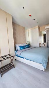 a bedroom with a large bed with blue sheets at Kuno - 2Br, Beachfront Jomtien in Jomtien Beach +69 photos