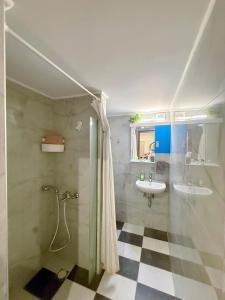 ein Badezimmer mit Dusche und Waschbecken in der Unterkunft Aloha Inn in Artemida