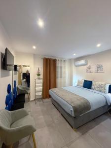 ein Schlafzimmer mit einem Kingsize-Bett und einem Stuhl in der Unterkunft Aloha Inn in Artemida