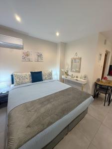 ein Schlafzimmer mit einem großen Bett und einem Schreibtisch in der Unterkunft Aloha Inn in Artemida